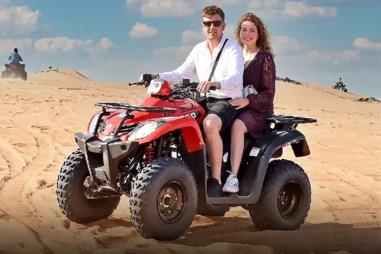 Tourist riding a rented quad bike in Dubai desert adventure area